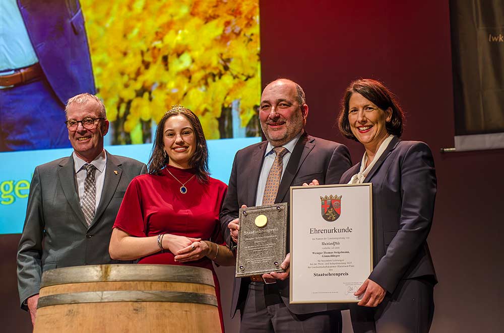 Daniela Schmitt, Ministerin für Wirtschaft, Verkehr, Landwirtschaft und Weinbau, Rheinland-Pfalz, die Pfälzische Weinkönigin Anna Antonia Cölsch sowie der Präsident der Landwirtschaftskammer Rheinland-Pfalz, Michael Horper, überreichen den 16. Staatsehrenpreis in Folge.